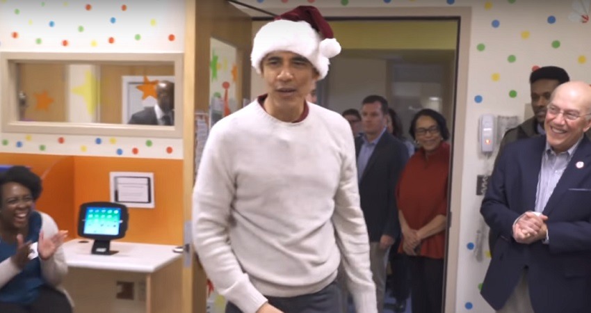 Barack Obama entrega regalos navidenos con un gorro de Papa Noel en un Hospital infantil